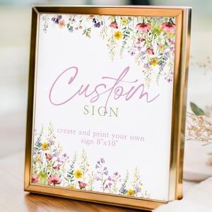 May include: A gold framed sign with the words "Custom Sign" in a script font. The sign is decorated with watercolor floral artwork and the text "create and print your own sign 8"x10".