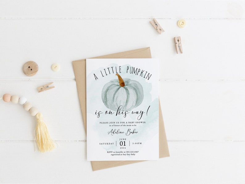 Pu&ograve; includere: Un invito a un baby shower con un'illustrazione ad acquerello di una zucca blu chiaro. Il testo recita "A little pumpkin is on his way!" e include la data, l'ora e le informazioni RSVP.