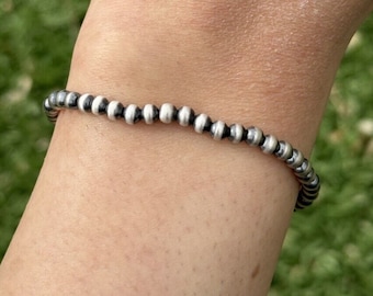 May include: A silver bracelet with alternating black and silver beads.
