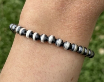 May include: A silver bracelet with alternating black and silver beads.