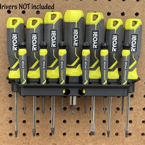 May include: A black screwdriver holder with 12 slots, holding 12 yellow and black screwdrivers. The holder is mounted on a pegboard. The text "screwdrivers NOT included" is visible at the top of the image.