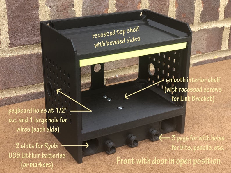 May include: Black 3D printed storage organizer with a door, two shelves, and pegboard holes. The top shelf has beveled sides and the bottom shelf has recessed screws. The organizer has slots for batteries and pegs for holding small items.