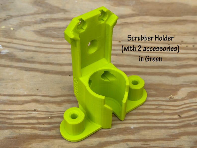 May include: A bright green scrubber holder with two accessory holders. The holder is made of plastic and has a cylindrical opening for the scrubber. The text "Scrubber Holder (with 2 accessories) in Green" is visible.