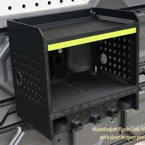 May include: Black wall-mounted storage unit with a yellow accent strip and a door open. The unit is mounted on Ryobi Link Wall Rails. "Mounted on Ryobi Link Wall Rails with door in open position" is written below the unit.