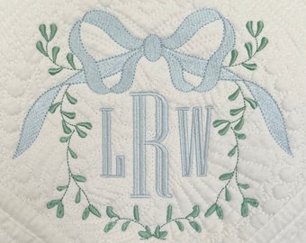 Personalisierte Erbstückdecke mit Rankenrahmen, großer Schleife und drei Buchstaben-Monogramm, rosa/blau, individuell bestickte Steppdecke mit Monogramm und Design