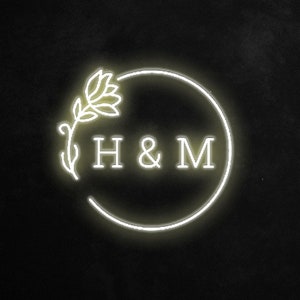 May include: A white neon sign with a floral design and the text "H & M" in a circle.