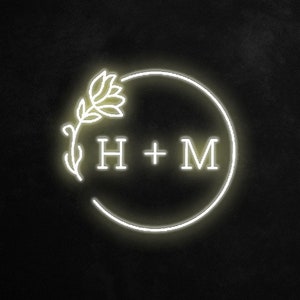 May include: A white neon sign with a floral design and the text "H + M" inside a circle.