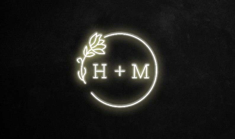 May include: A white neon sign with a floral design and the text "H + M" inside a circle.