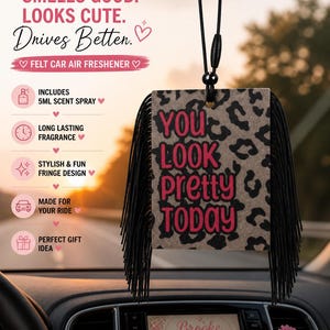 May include: Felt car air freshener with a leopard print design and the text "YOU LOOK PRETTY TODAY" in pink. The freshener has black fringe and hangs from a car's rearview mirror. Includes a 5ml scent spray.