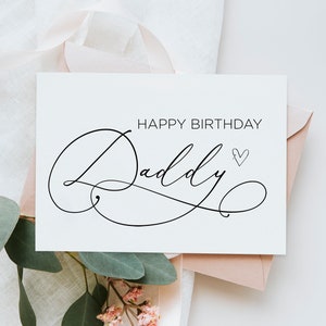 Puede incluir: Una tarjeta blanca con caligrafía negra que dice "Feliz cumpleaños Papá" con un pequeño corazón dibujado al lado de la palabra "Papá". La tarjeta está sobre un sobre rosa y una superficie blanca.