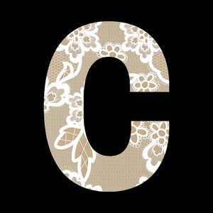 May include: A white lace letter C on a brown background. The lace has a floral pattern.