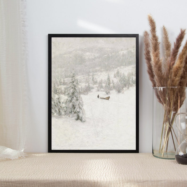 Peut inclure: Une peinture de paysage d'hiver encadr&eacute;e repr&eacute;sentant une sc&egrave;ne de for&ecirc;t enneig&eacute;e avec une petite silhouette tirant un tra&icirc;neau. La peinture est dans un cadre noir et a un fond blanc.