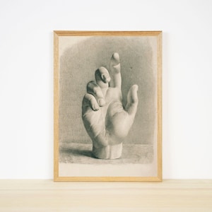 May include: A black and white drawing of a hand in a vintage style frame.