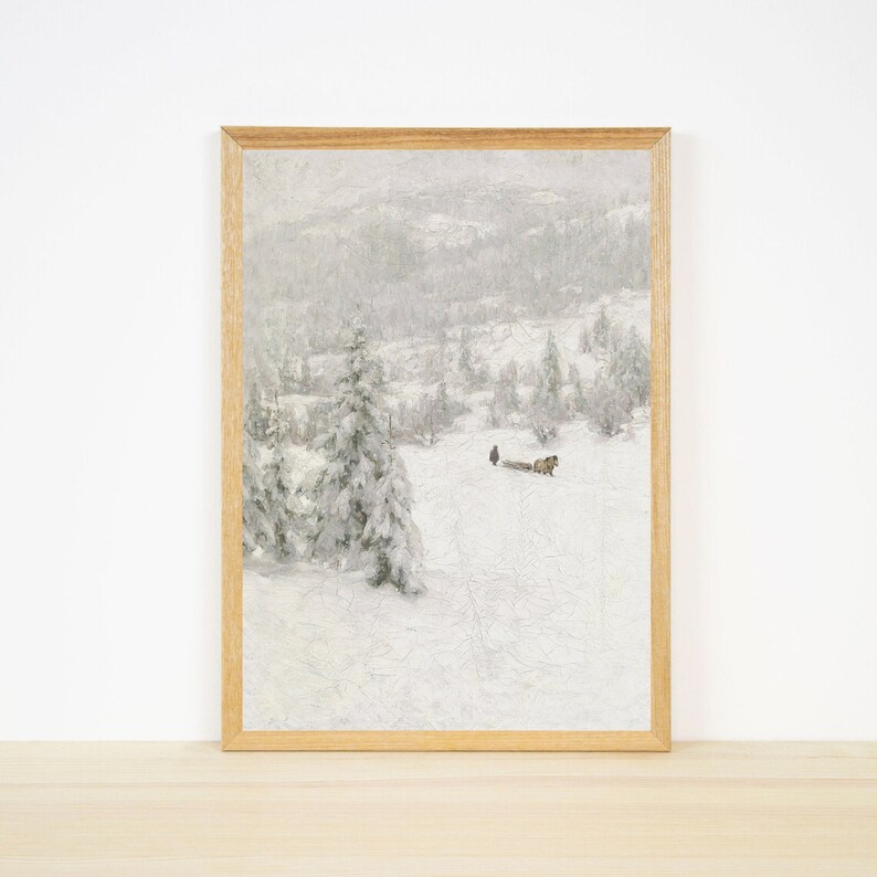 Peut inclure: Une peinture encadr&eacute;e repr&eacute;sentant un paysage d'hiver enneig&eacute; avec une carriole tir&eacute;e par un cheval au loin. La peinture est dans un cadre en bois clair et a un fond blanc.