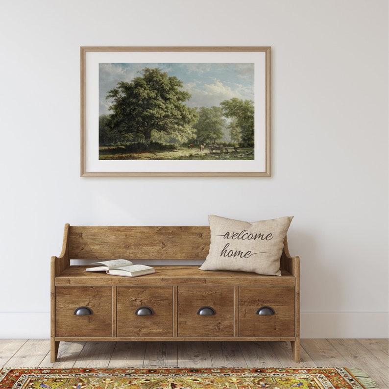 Pu&ograve; includere: Una panca portaoggetti in legno con quattro cassetti e un cuscino con la scritta "welcome home". La panca &egrave; davanti a un muro bianco con un dipinto di paesaggio incorniciato sopra.