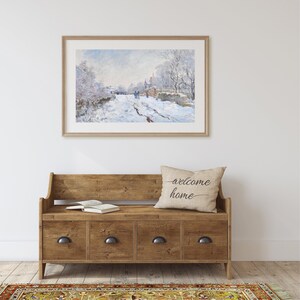 Pu&ograve; includere: Una panca in legno con quattro cassetti e un cuscino con la scritta "welcome home". La panca &egrave; davanti a un muro bianco con un dipinto incorniciato di una scena di strada innevata.