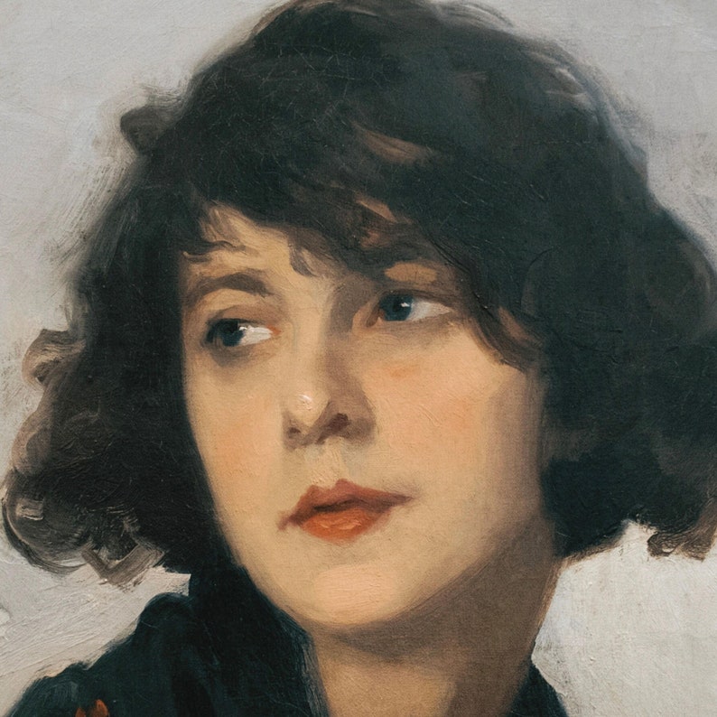 Op de afbeelding: Een schilderij van een vrouw met donkerbruin haar, die een donkerblauw shirt draagt. Haar gezicht is verlicht en ze heeft een zachte, vriendelijke uitdrukking. De achtergrond is lichtgrijs.
