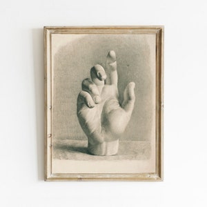 May include: A black and white drawing of a hand, framed in a vintage style. The hand is depicted realistically, with detailed shading and lines.