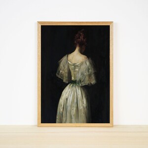 May include: A framed painting of a woman in a white dress with a green sash, standing with her back to the viewer against a dark background.