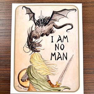May include: Watercolor illustration featuring a dragon and a figure with long blonde hair, a shield, and a sword. The text "I AM NO MAN" is displayed in black. The artwork is signed "Jennifer Dixon".
