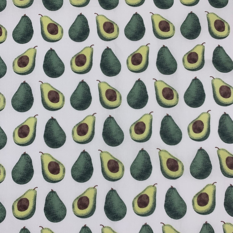 May include: White fabric with a repeating pattern of green avocado halves. The avocados are arranged in rows and columns.
