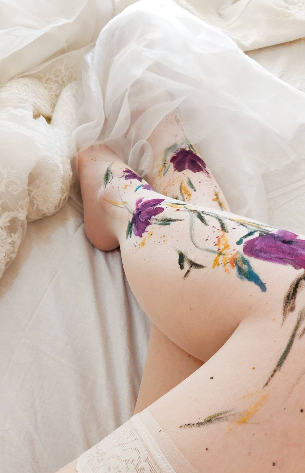 Close up half-turn shot of pure white stockings with floral lace welt on  woman's thighs.