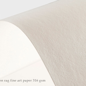 Pode incluir: Close-up de um papel de arte fino texturizado de cor branco-creme. O papel &eacute; 100% algod&atilde;o e pesa 316 g/m&sup2;.