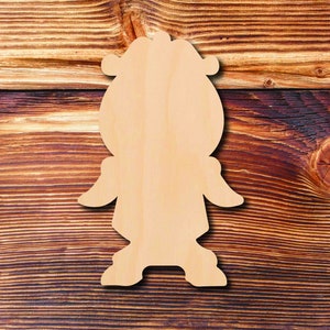 May include: A wooden cutout of a person with a large head and a simple design. The cutout is light brown and has a smooth surface.
