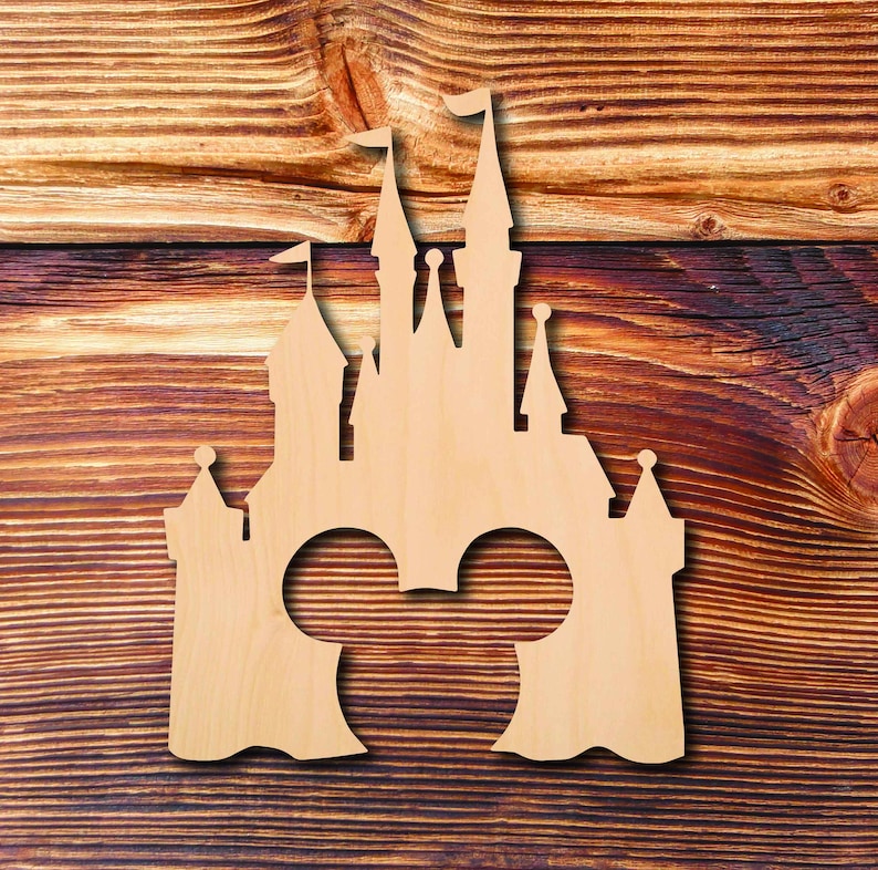 K&ouml;nnte beinhalten: Ein Holzausschnitt eines Schlosses mit Mickey-Maus-Ohren in der Mitte. Das Schloss ist hellbraun und vor einem Holzmaserungshintergrund platziert.