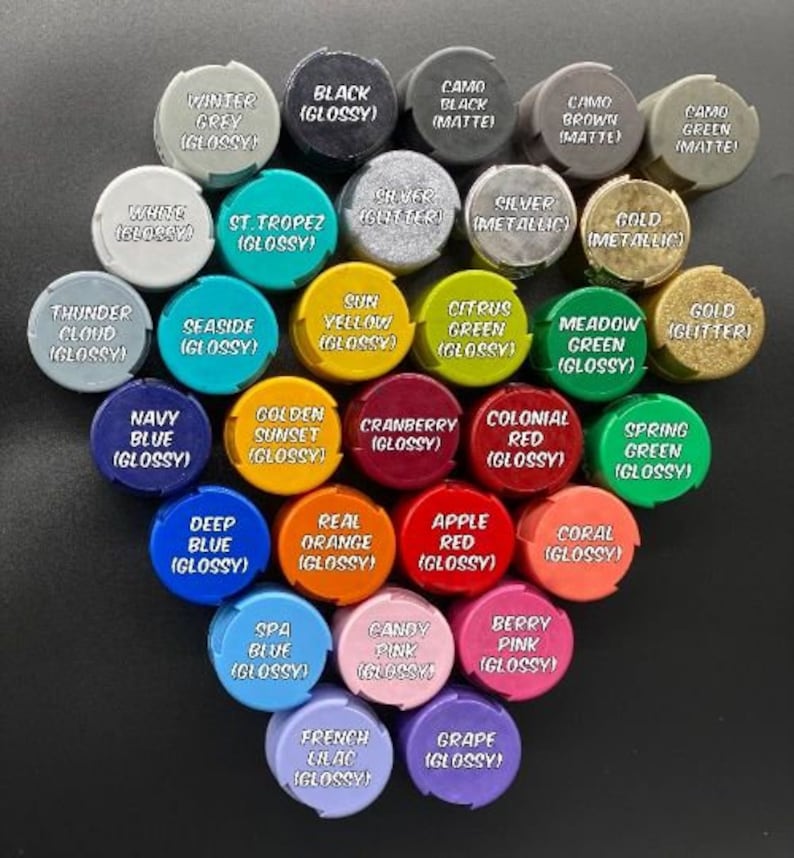 May include: Assortment of paint caps in various colors, including black, white, red, green, blue, yellow, orange, pink, and purple. Each cap has a different color and a name printed on it, such as "Winter Grey", "Black (Glossy)", "St. Tropez (Glossy)", "Sun Yellow (Glossy)", "Navy Blue (Glossy)", "Deep Blue (Glossy)", "Spa Blue (Glossy)", "French Lilac (Glossy)", and "Grape (Glossy)".