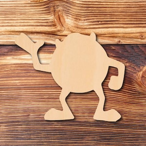 May include: A wooden cutout of a cartoon monster with a large round body, two arms, and two legs. The monster is standing on a wooden surface.