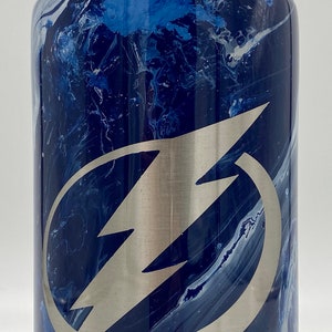 May include: A stainless steel water bottle with a black handle and a blue and white marbled design. The bottle has a silver lightning bolt logo on the front.