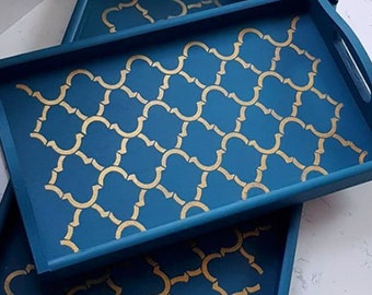 May include: Three wooden serving trays with blue paint and a gold geometric pattern. The trays are stacked on top of each other.