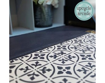 May include: A close-up of a black and white patterned tile floor. The tiles are arranged in a repeating geometric pattern. The floor is part of a piece of furniture that has been upcycled. The text "upcycle arcade" is visible in a circle on the furniture.