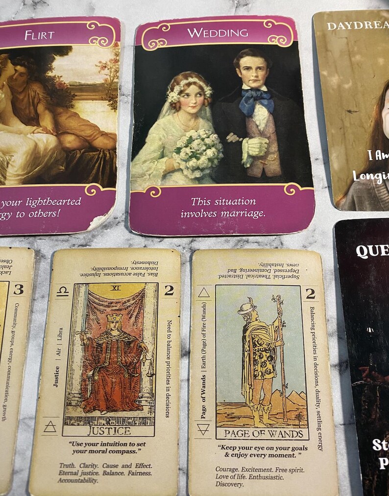 May include: A set of tarot cards with colorful illustrations and text. The cards are arranged in a grid with the top row showing the cards "Flirt", "Wedding", and "Daydream". The bottom row shows the cards "Justice", "Page of Wands", and "Queen of Swords".