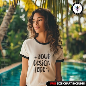 Może przedstawiać: Biała koszulka z czarnym wykończeniem wokół szyi i rękawów. Koszulka ma napis "YOUR DESIGN HERE" nadrukowany z przodu czarnym kolorem z małymi gwiazdkami wokół tekstu.