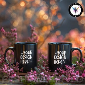 May include: Two black ceramic mugs with white text that reads "Your Design Here" on a background of pink flowers.