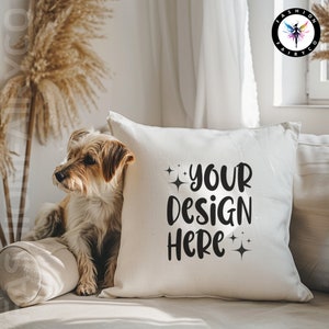Może przedstawiać: Biała poduszka z napisem "YOUR DESIGN HERE" czarnymi literami i dwiema małymi błyszczącymi gwiazdkami po obu stronach tekstu. Poduszka leży na jasnobrązowej kanapie, na której siedzi mały brązowy pies.