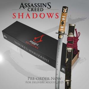 Może przedstawiać: Obraz promocyjny dla Assassin's Creed Shadows, przedstawiający miecz wakizashi i jego pochwę. Miecz ma beżową rękojeść i srebrne ostrze. Pochwa jest czarna ze złotymi akcentami i czerwoną linką. Widoczne jest również czarne pudełko z logo gry i napisem "YASUKE'S WAKIZASHI".