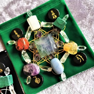 May include: A green velvet pouch with a gold geometric pattern and various crystals, including clear quartz, amethyst, citrine, and blue lace agate. The pouch also features black circular stones with Chinese characters.