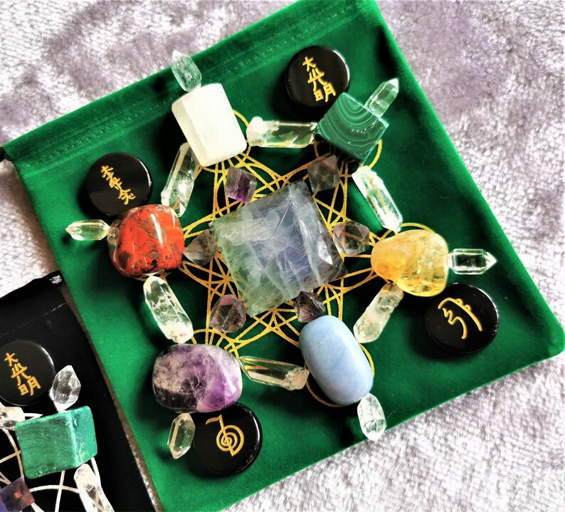 May include: A green velvet pouch with a gold geometric pattern and various crystals, including clear quartz, amethyst, citrine, and blue lace agate. The pouch also features black circular stones with Chinese characters.