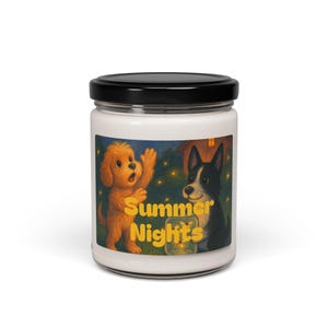 Puede incluir: Un tarro de vela blanco con tapa negra. La etiqueta presenta una ilustración de dibujos animados de dos perros, uno dorado y otro blanco y negro, con el texto "Summer Nights" en amarillo. Los perros están sobre un fondo de luciérnagas.