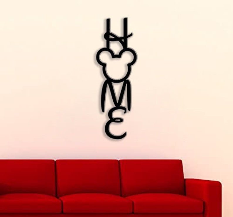 May include: Black metal wall decor with the word "HOME" spelled out in a stylized font. The letter "O" is replaced with a cartoon bear head.