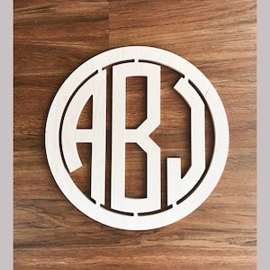 May include: A white wooden circle with the letters A, B, and J cut out in a monogram style.