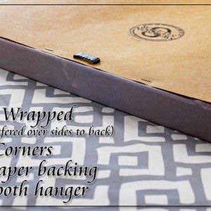 May include: Close-up of the back of a gallery wrapped canvas print. The canvas is wrapped around the sides and the image is printed on the sides. The back of the canvas is covered in brown kraft paper and has a gator tooth hanger.