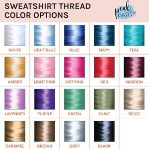 May include: A color chart displays thread color options for sweatshirts. The chart includes spools of thread in various colors, such as white, light blue, blue, navy, teal, amber, light pink, hot pink, red, maroon, lavender, purple, green, olive, beige, caramel, brown, grey, and black.