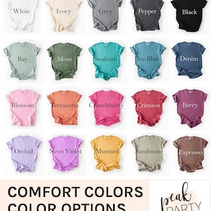 May include: A collection of Comfort Colors t-shirts in various colors, including white, ivory, grey, and black. Other colors include bay, moss, seafoam, and denim. The text "COMFORT COLORS COLOR OPTIONS" is displayed below the shirts.