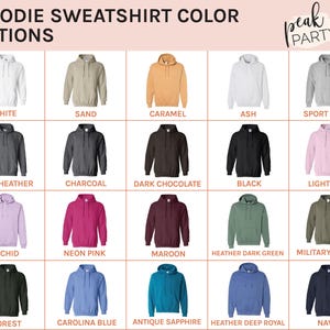 May include: A color chart displays various hoodie sweatshirt color options. Colors include white, sand, caramel, ash, sport grey, dark heather, charcoal, dark chocolate, black, light pink, orchid, neon pink, maroon, heather dark green, military green, forest, carolina blue, antique sapphire, heather deep royal, and navy.