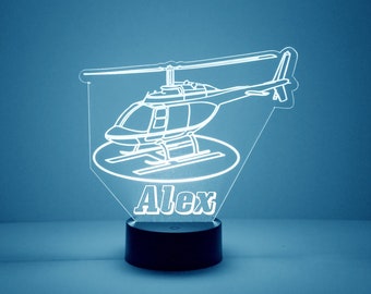 May include: A white outline of a helicopter with the name "Alex" underneath. The helicopter is on a black base.