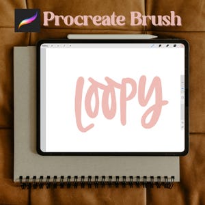 Op de afbeelding: Digitale illustratie op een tablet, met het woord "loopy" in zachtroze script. De tablet ligt op een grijze spiraalgebonden notitieblok. De woorden "Procreate Brush" staan bovenaan, met het Procreate-logo.